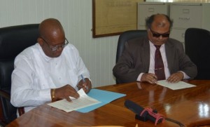 FLASH BACK: Finance Minister, Winston Jordan (left) and Fedders Lloyd’s representative, Ajay Jha, signing the Memorandum of Understanding to build the Specialty Hospital