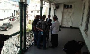 Rice importer, Jack Charles backing camera (with bottle in hand) and lawyers outside the Belize High Court room.