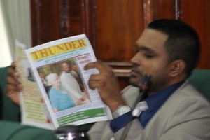 PPPC parliamentarian, Nigel Dharmlall reading a copy of his party's official organ, Thunder.
