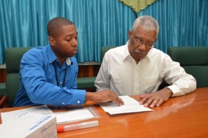 Mr. Shawn Manbodh, Quality Manager and Medical Technologist explains to President David Granger what information will be garnered from the results of the Ancestry DNA test