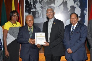 Chairperson of the Public Service Commission of Inquiry, Professor Harold Lutchman presents the Report to President David Granger, in the presence of Commissioners Ms. Sandra Jones and Prime Minister Moses Nagamootoo