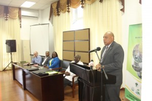 Minister of Natural Resources, Raphael Trotman addressing the opening of the EITI workshop. Seated are (from far left) Policy Forum Guyana's representative, Mike Mc Cormack; private sector representative, Hilbert Shields; Junior Natural Resources Minister, Simona Broomes and Chairman of the opening session, Ambassador Rudy Collins.