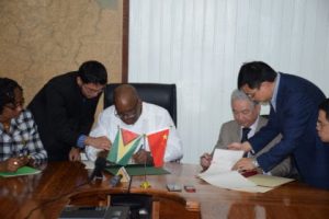 Minister of Finance, Winston Jordan, and outgoing Ambassador of the People’s Republic of China, Zhang Limin signing the Framework Agreement for the East Coast Road expansion at the Ministry of Finance