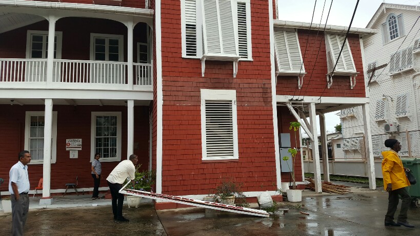 Ministry of the Presidency workers fetching away the Cheddi Jagan Research Centre's sign after pulling it down from the front of the building.